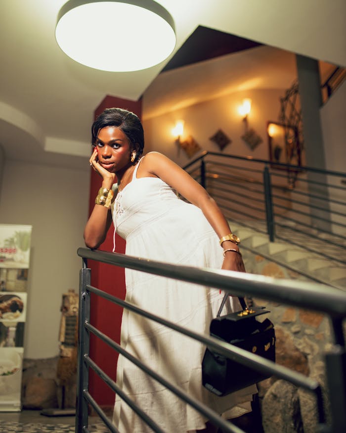gallery-3 Stylish woman poses elegantly indoors on a staircase in chic fashion.